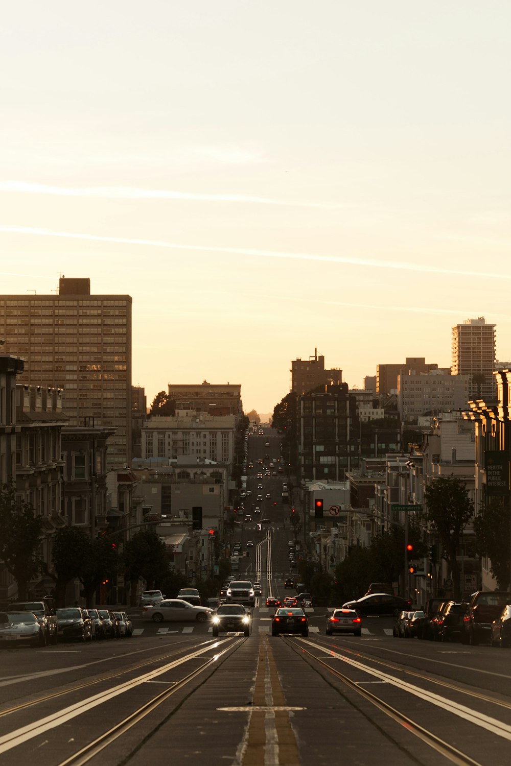 a city street filled with lots of traffic next to tall buildings