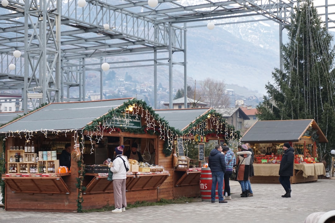 a group of people standing outside of a store, Christmas market in the Aosta