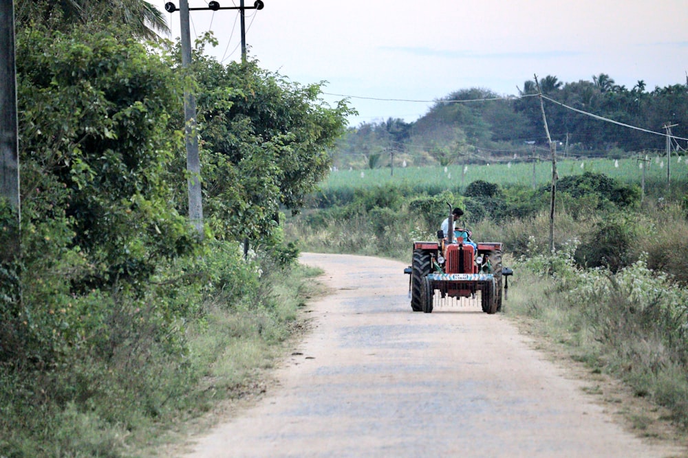 a man driving a tractor down a dirt road