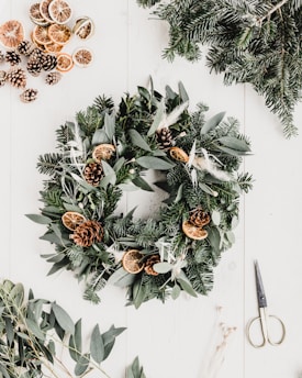 a wreath with pine cones and evergreen leaves