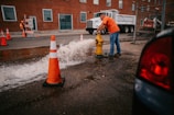 a man in an orange shirt is working on a fire hydrant