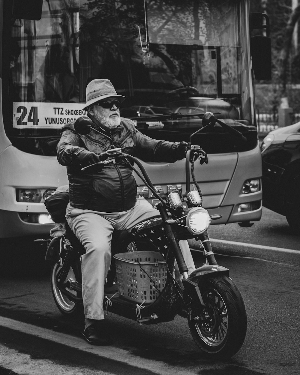 a man riding on the back of a motorcycle down a street