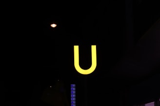 Close-up of Upnet's bright yellow logo on a dark background at a local event booth.