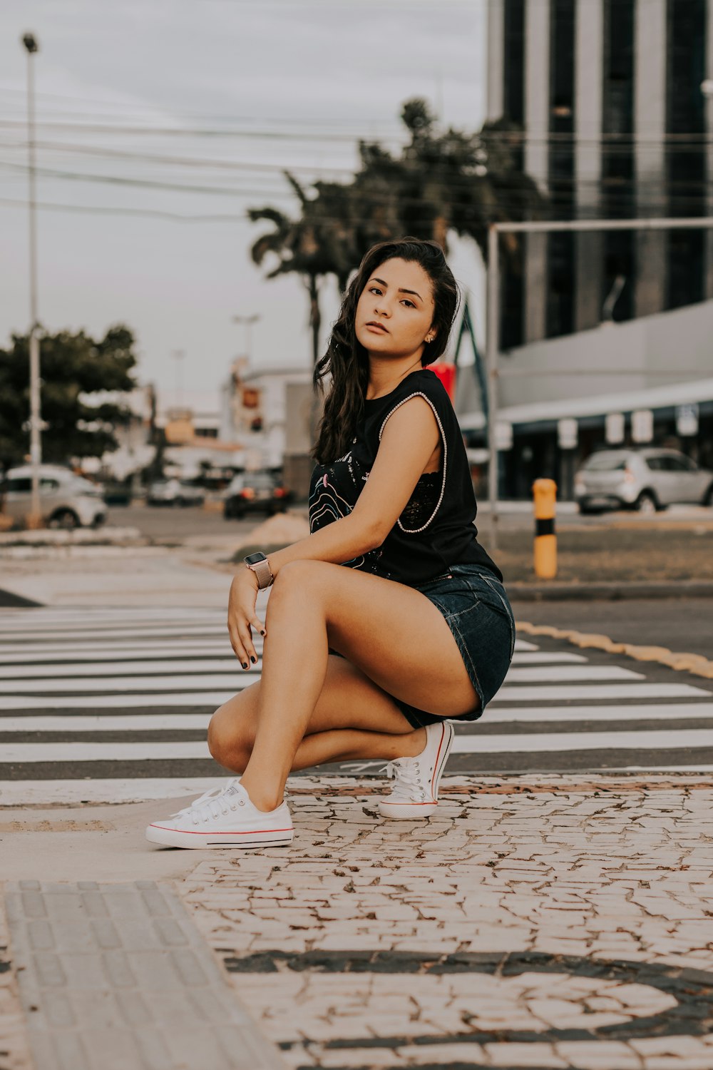 a woman sitting on a crosswalk with her legs crossed