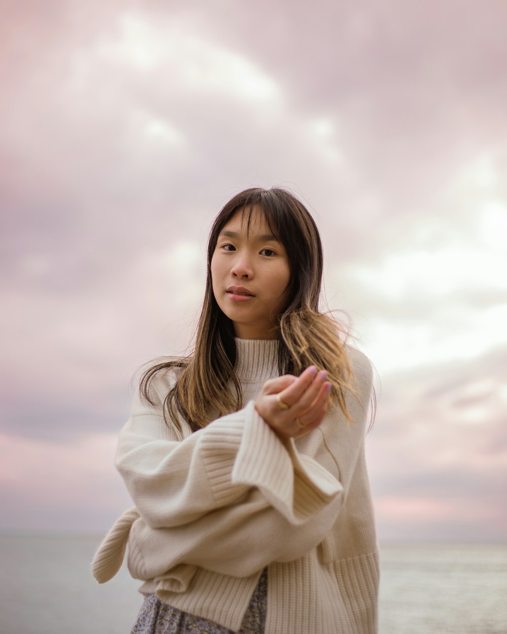 a woman standing in front of a body of water