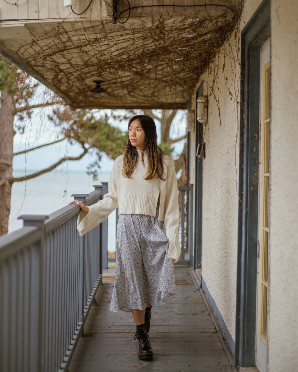 a woman standing on a porch next to a building