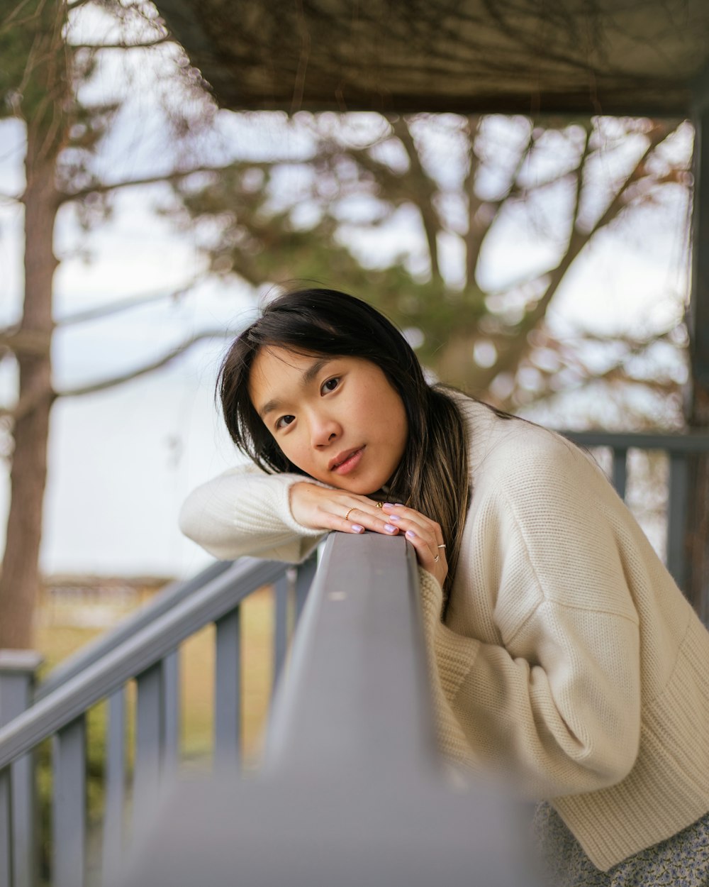 a woman leaning on a railing looking at the camera