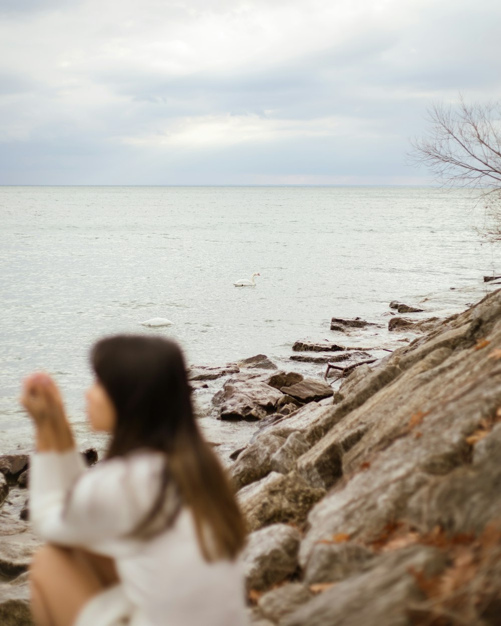 Une femme assise sur un rocher près de l’eau