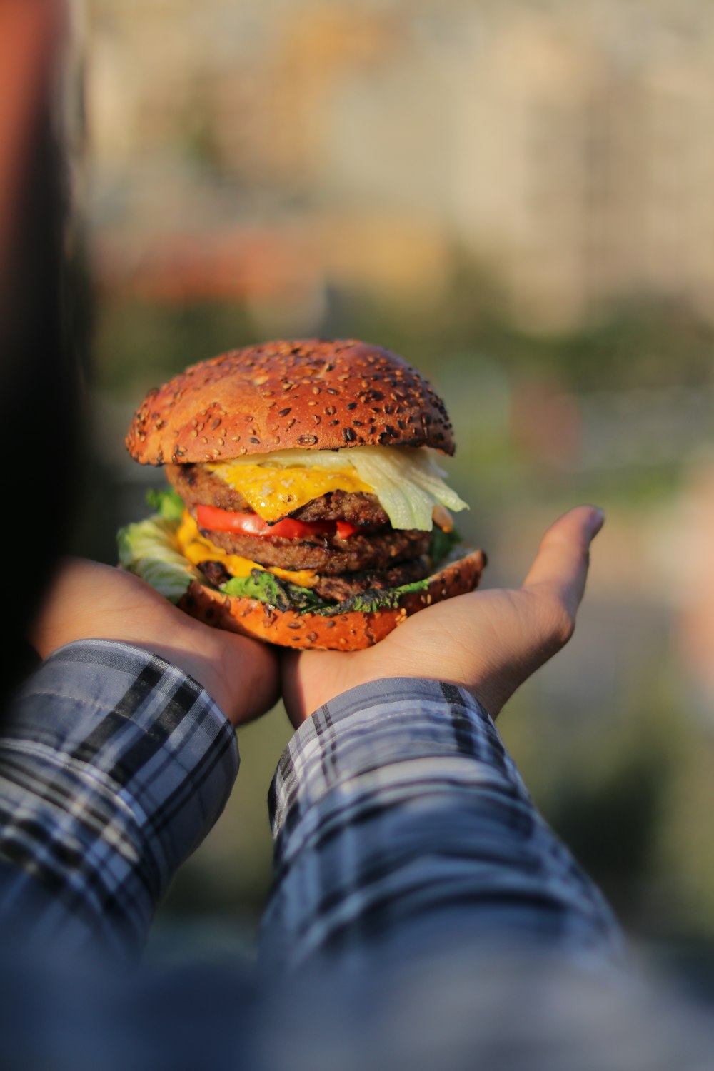 a person holding a hamburger in their hands