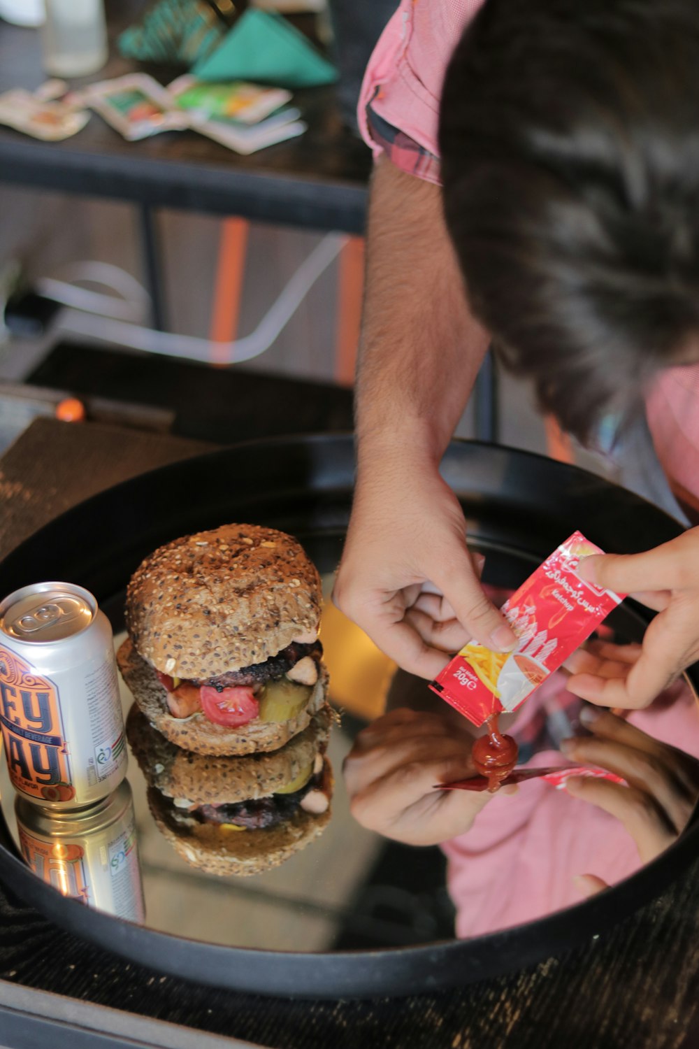 Un hombre está poniendo una bolsa de papas fritas en una hamburguesa