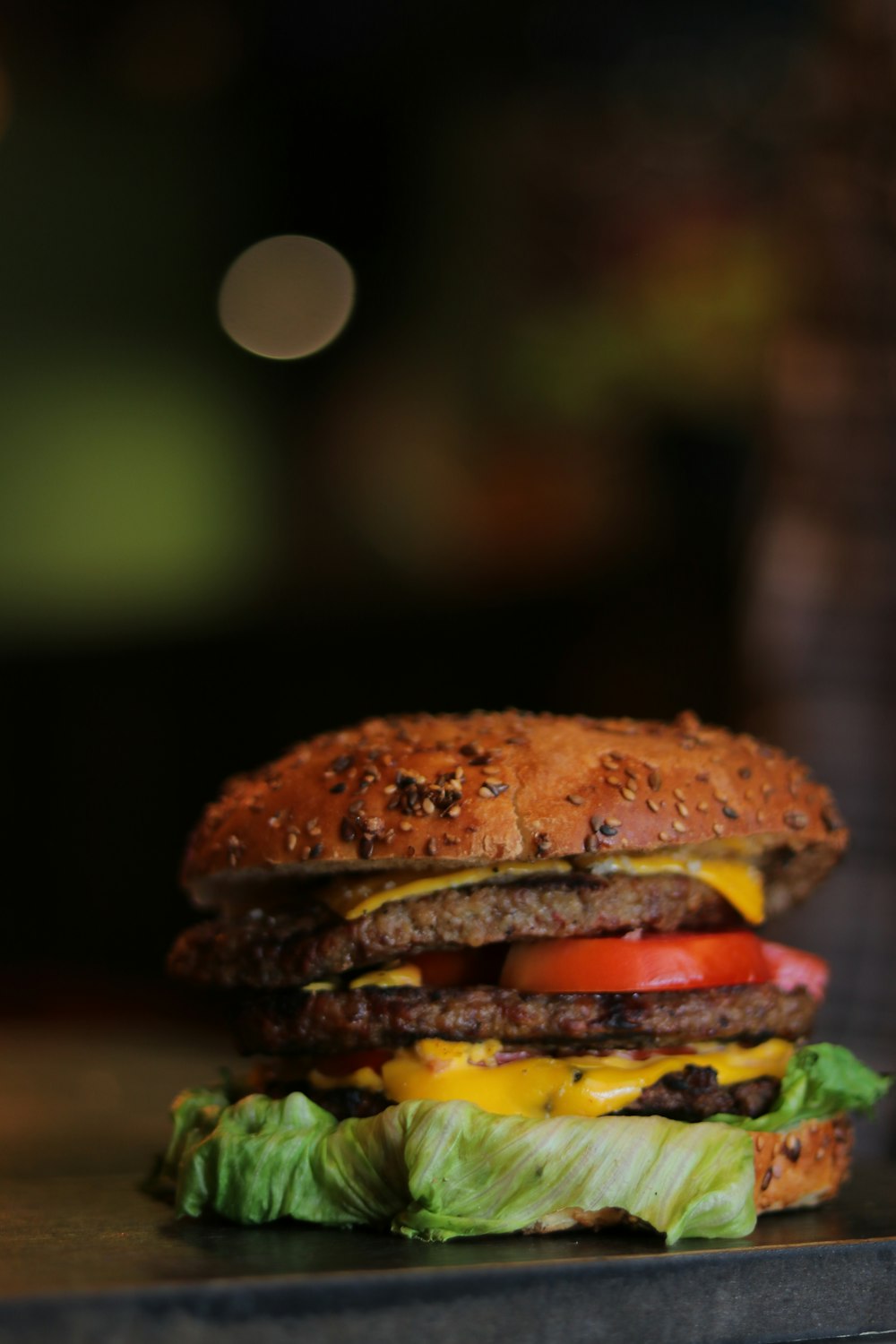 a cheeseburger with lettuce and tomato on a table