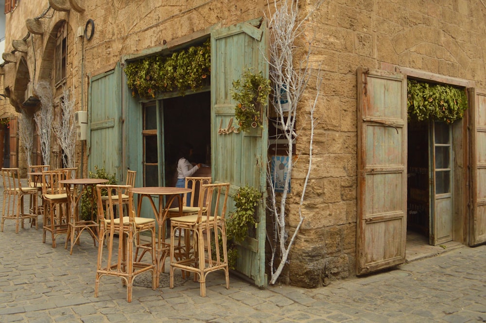 a man standing outside of a building next to tables and chairs