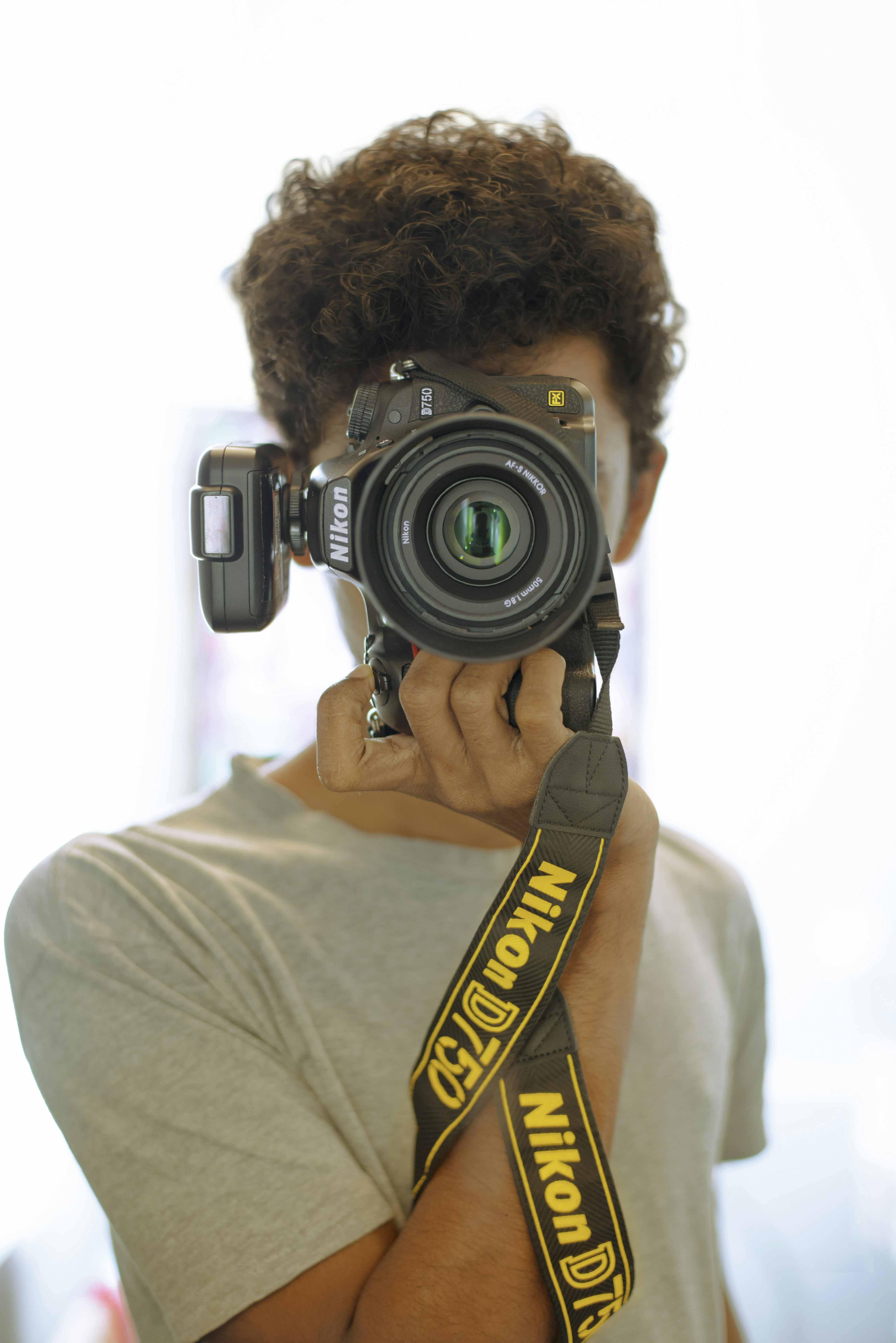 A man holding a camera up to his face photo – Free Portrait Image on ...