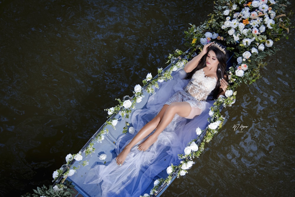 a woman in a white dress is floating down a river