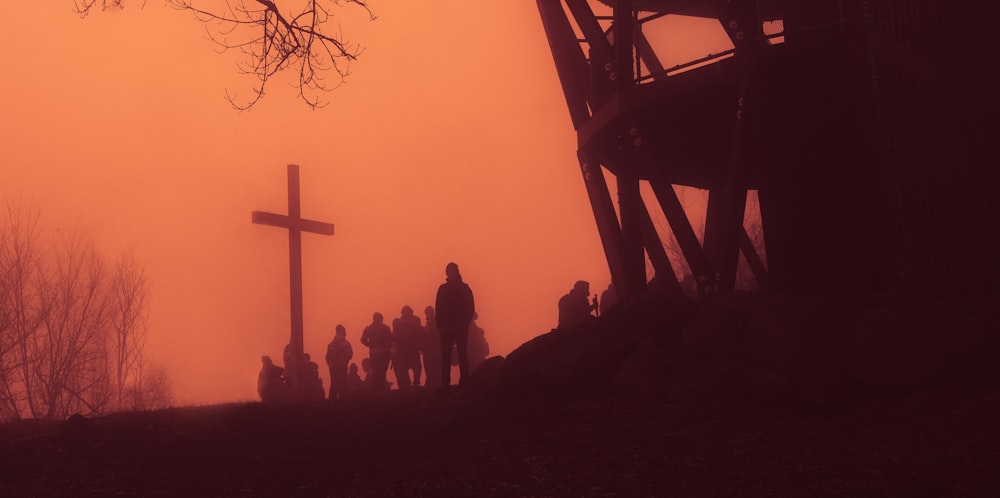 Un gruppo di persone in piedi davanti a una croce