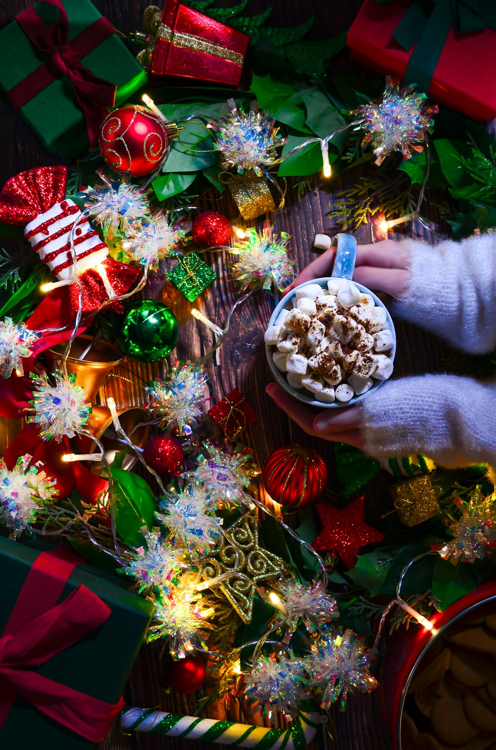 a person holding a bowl of food in front of christmas decorations