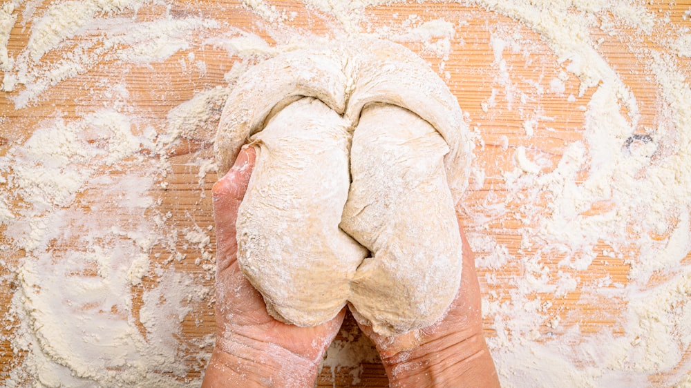 a person holding a piece of bread in their hands