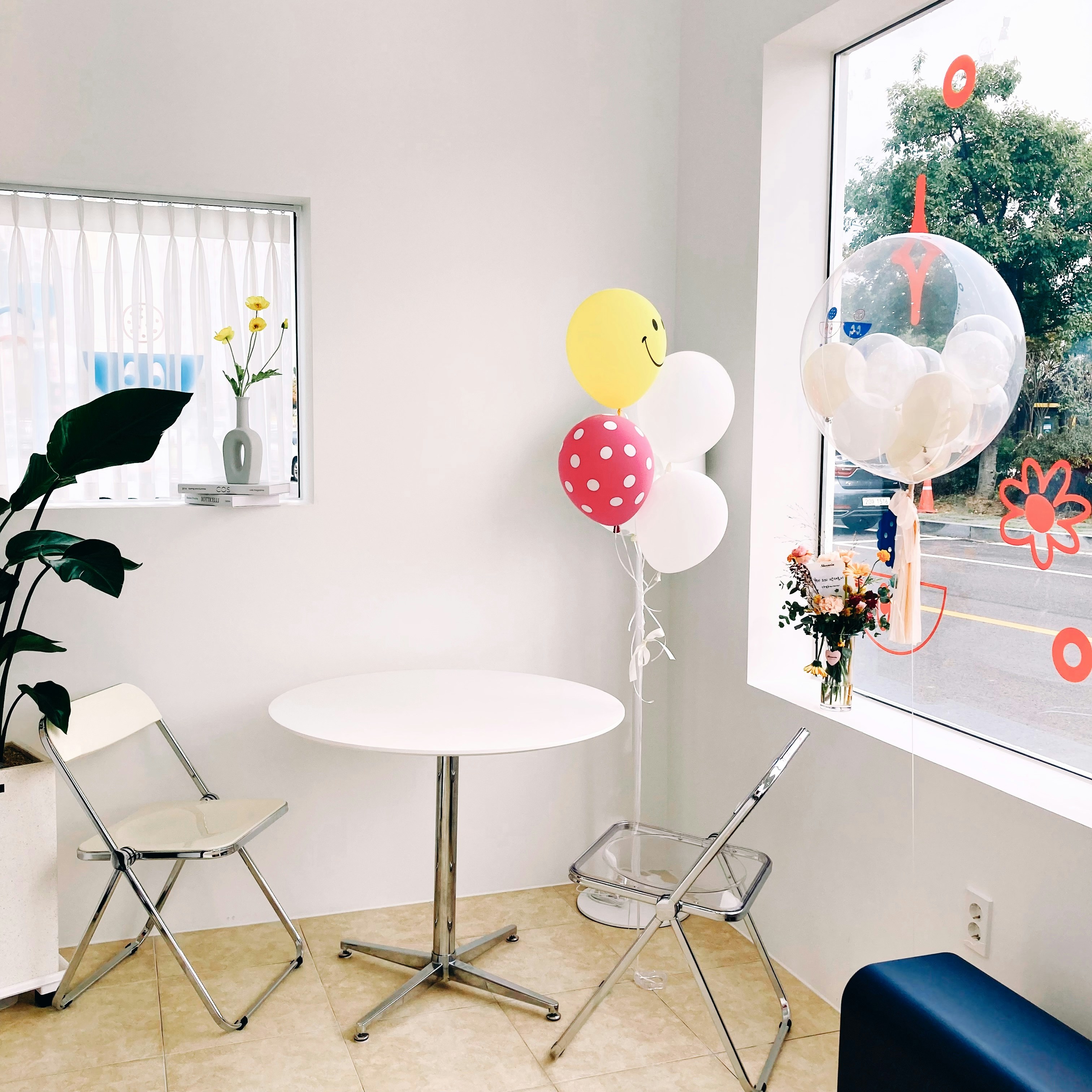 Colorful birthday gift boxes with ribbons on white table, bright airy room, warm natural light