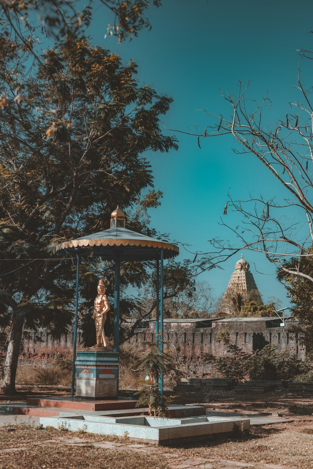 a gazebo with a statue of a woman on top of it