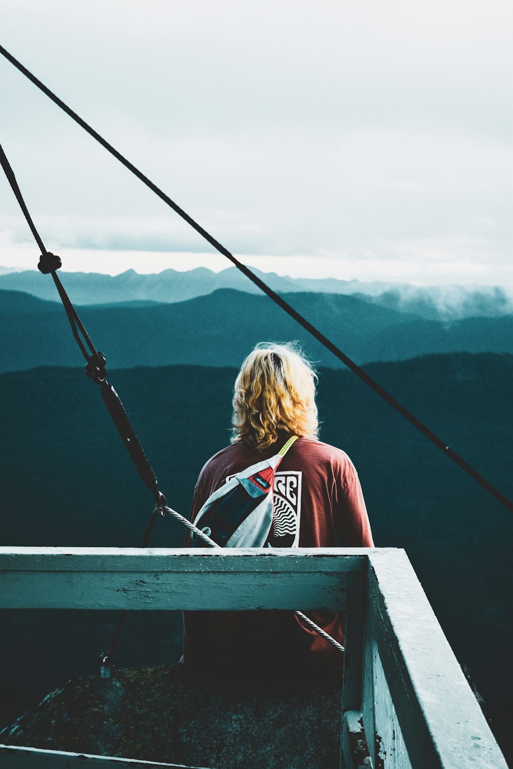 a person sitting on top of a wooden bench