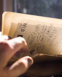 a person holding a book with writing on it