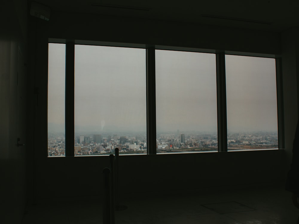 a person looking out a window at a city