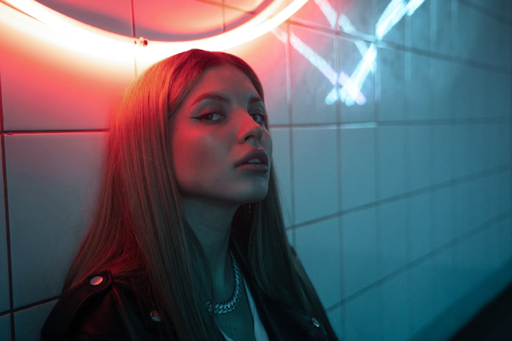 a woman standing in front of a neon sign