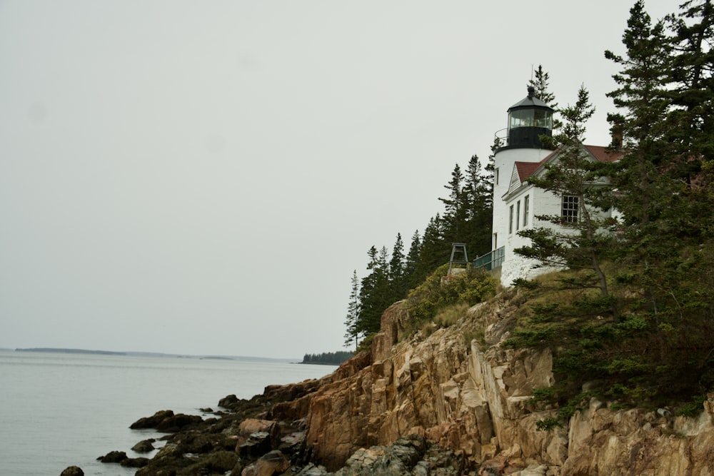 a lighthouse on a rocky cliff near the ocean