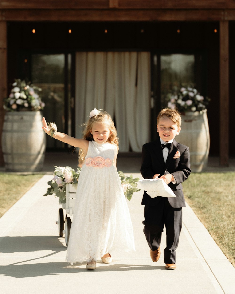 a young boy and girl walking down a sidewalk