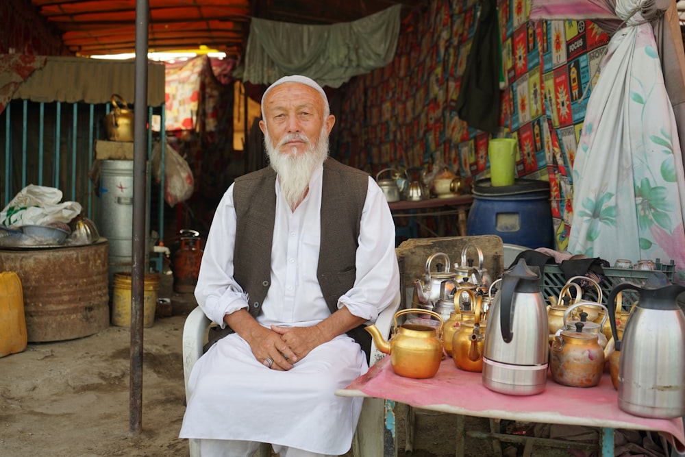 a man with a long white beard sitting in front of a table