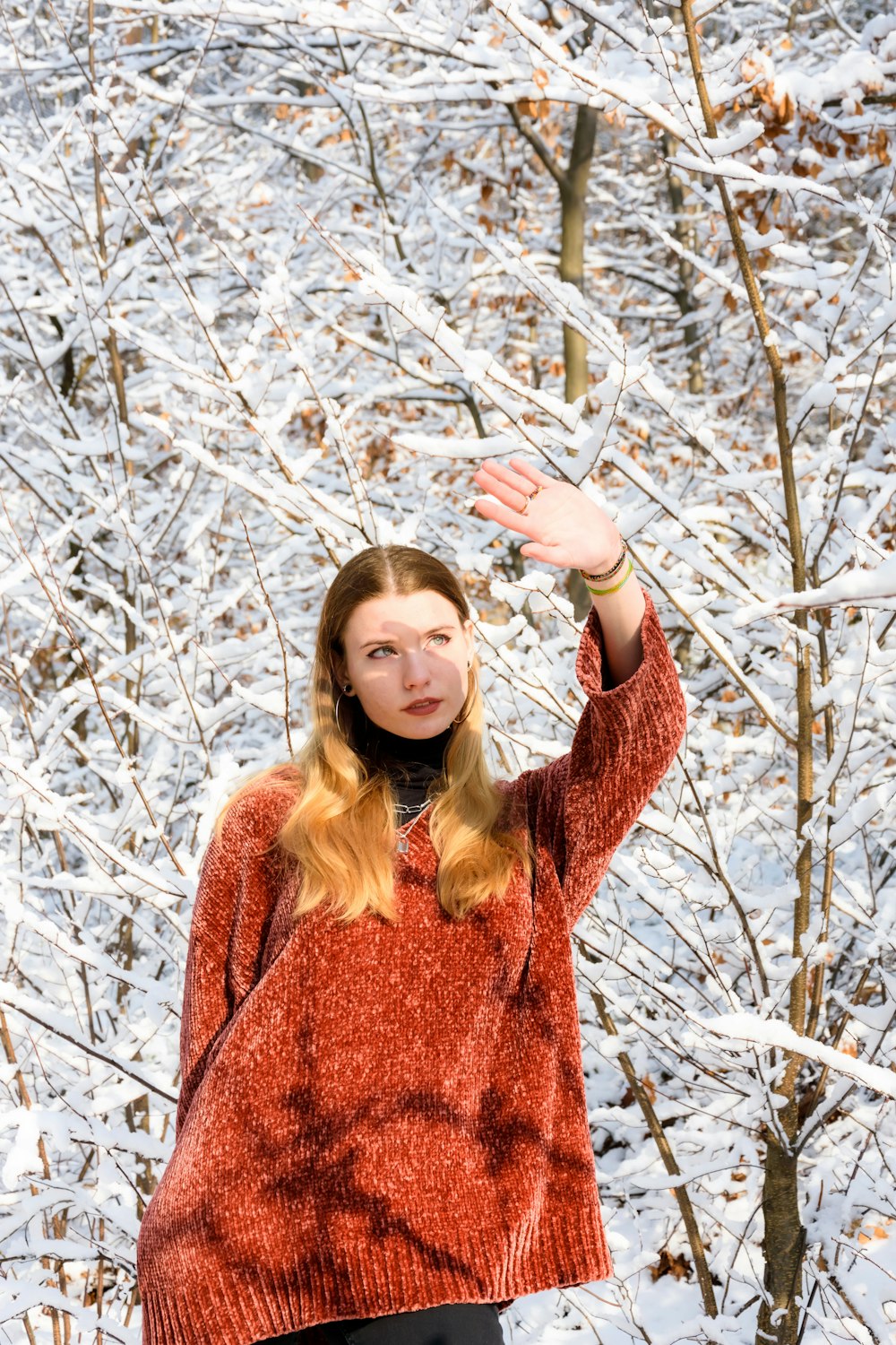 a woman in a red sweater is standing in the snow