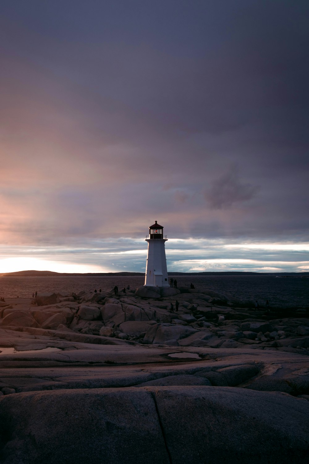 a light house sitting on top of a rocky hill