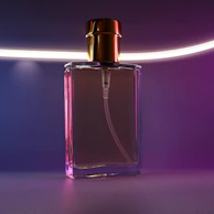 Perfume bottles with tropical-inspired designs, glowing softly on a modern black and white surface.