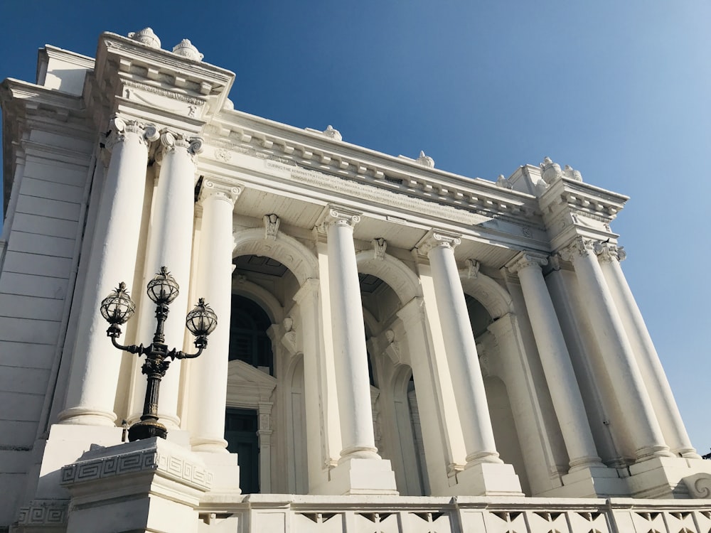 a white building with columns and a street light