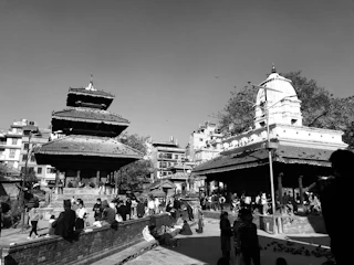 Volunteers handing out informational pamphlets about Buddhist heritage in a busy city square.