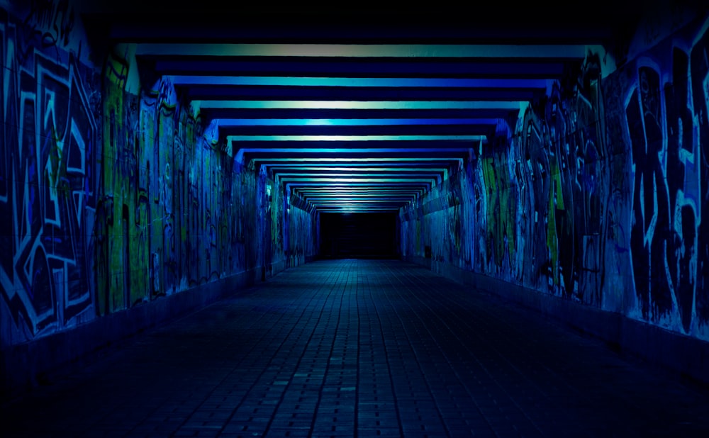 a dark tunnel with graffiti all over it
