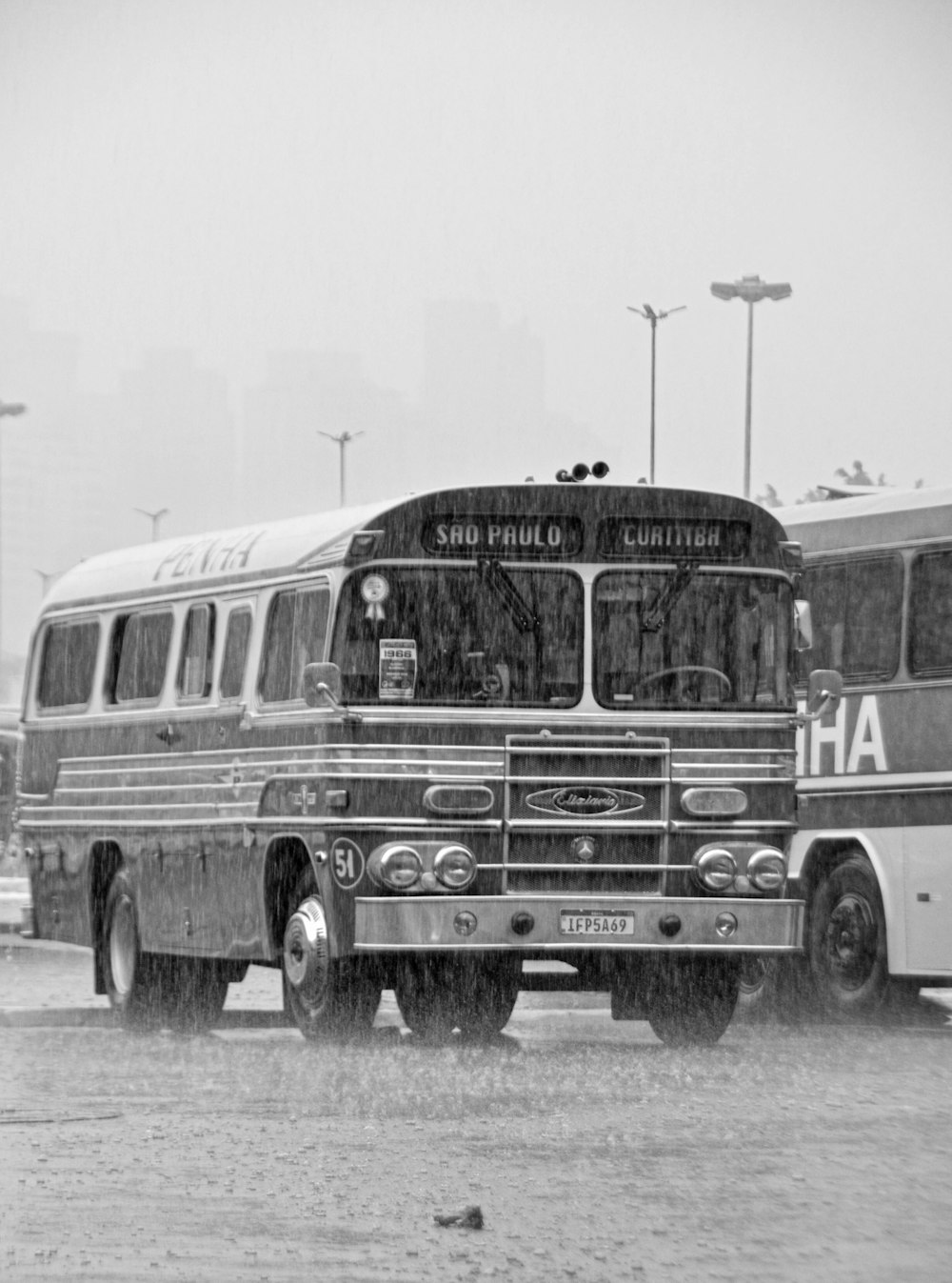a black and white photo of a bus in the rain