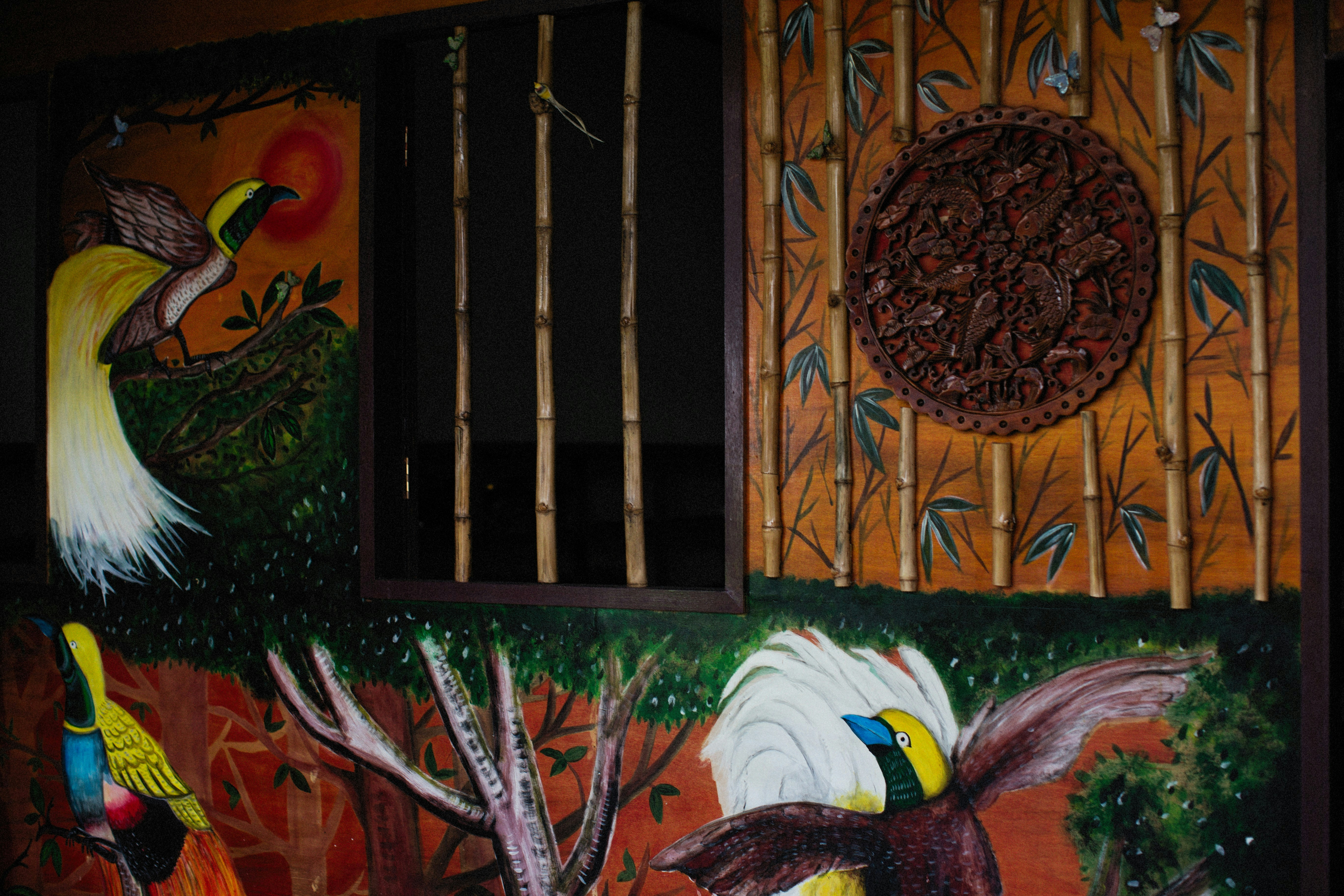 a painting on a wall of birds and bamboo