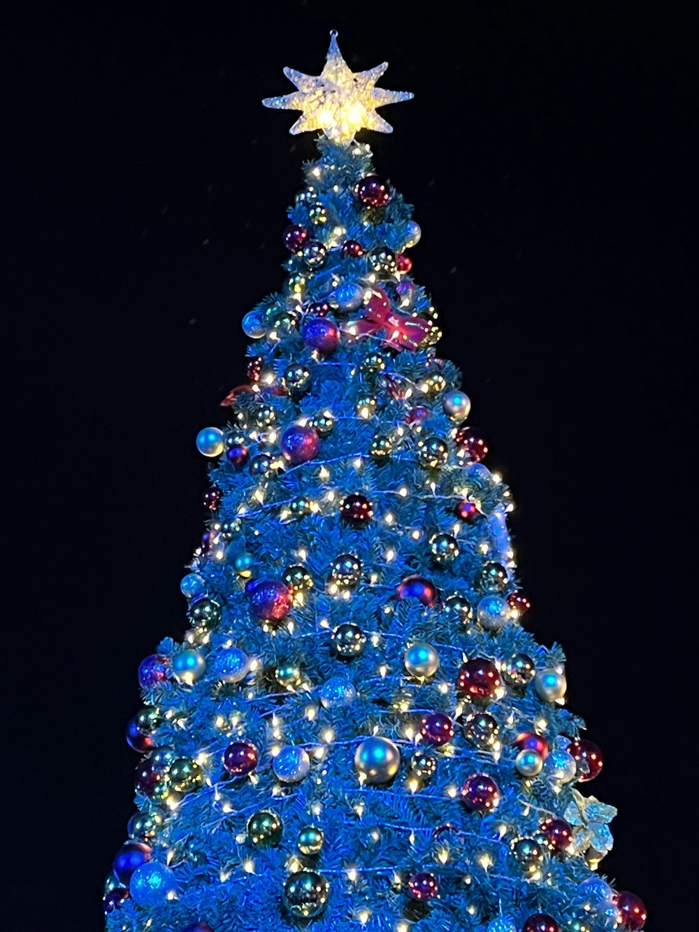 a large blue christmas tree with a star on top
