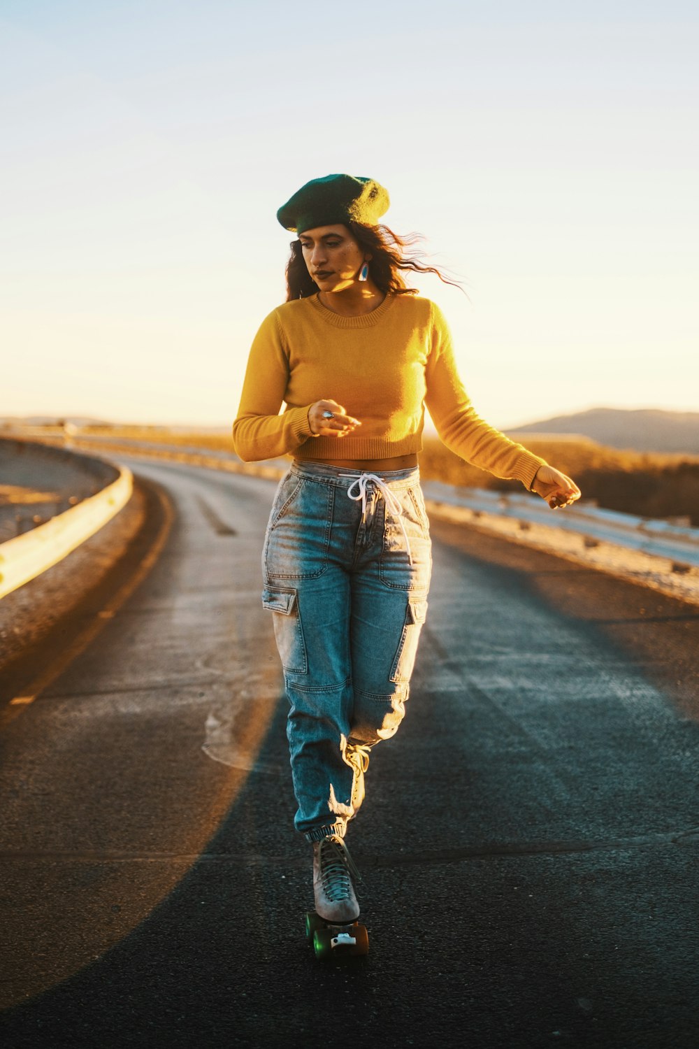 a woman riding a skateboard down a road