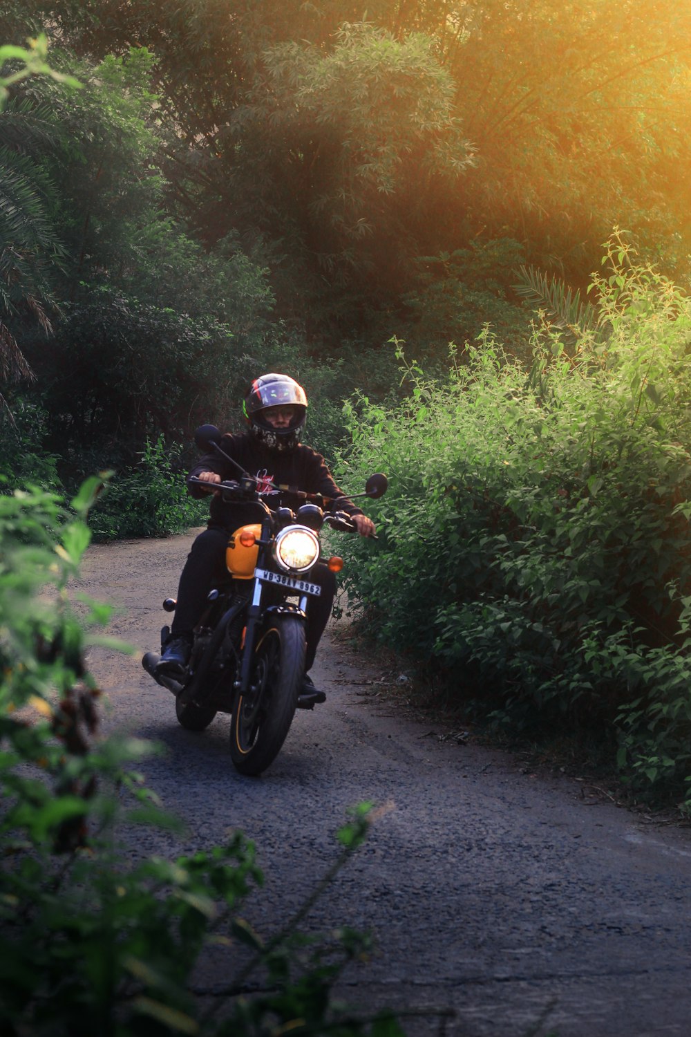 a man riding a motorcycle down a dirt road