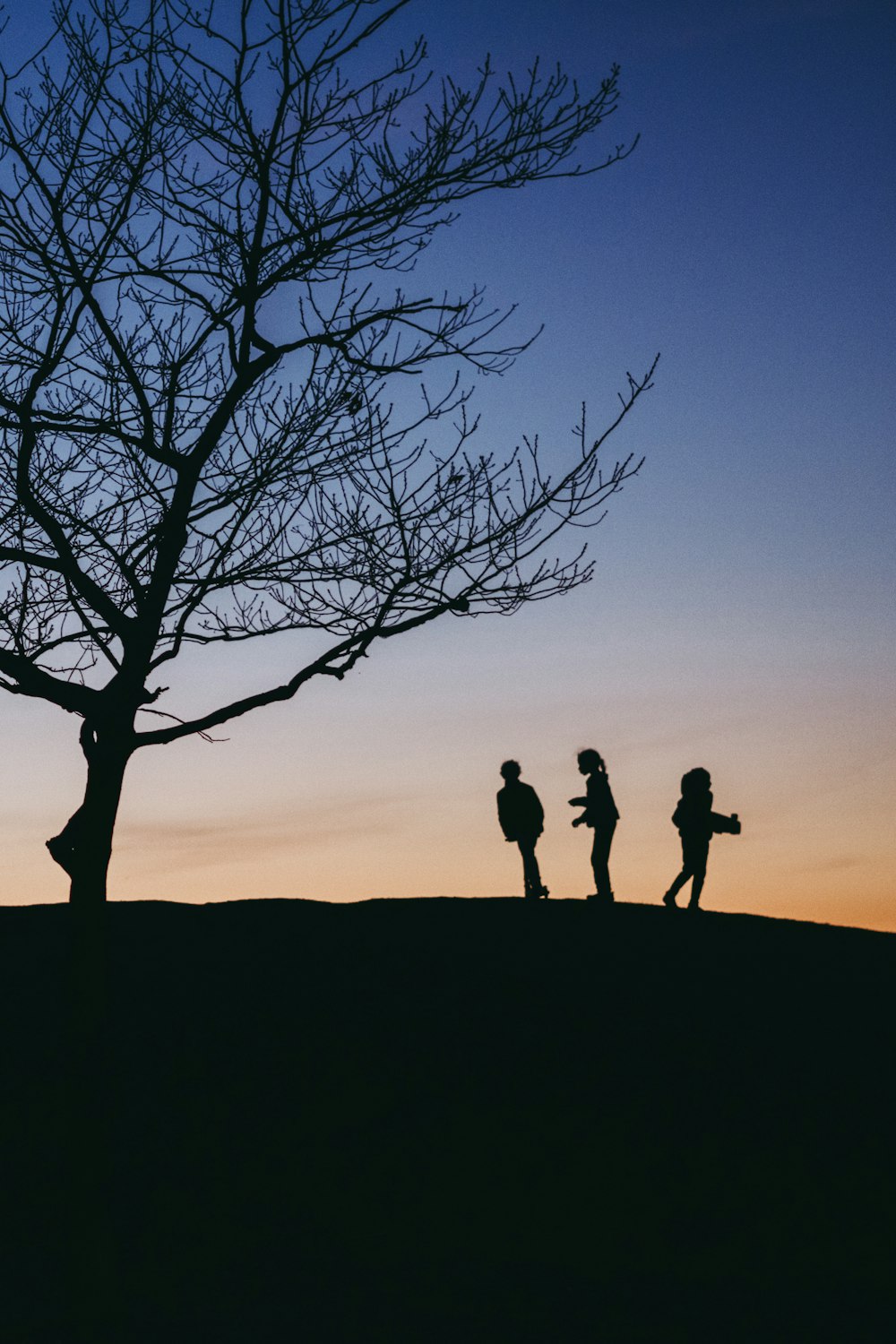 a group of people standing next to a tree