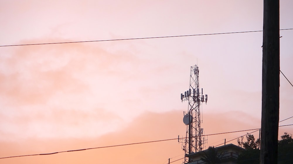 a cell phone tower with a sunset in the background