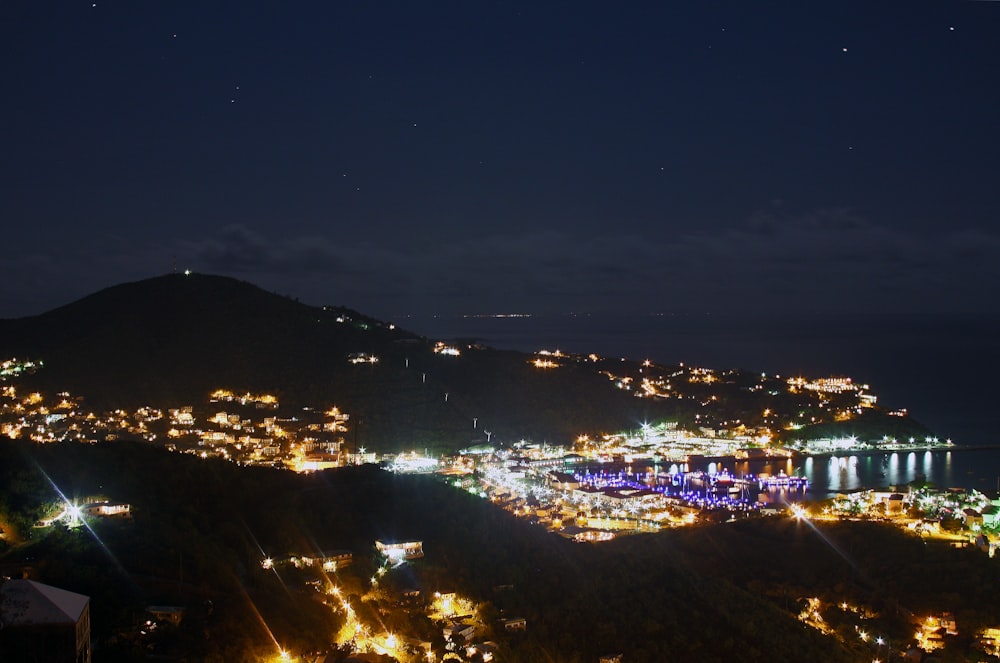 a night time view of a city with a mountain in the background