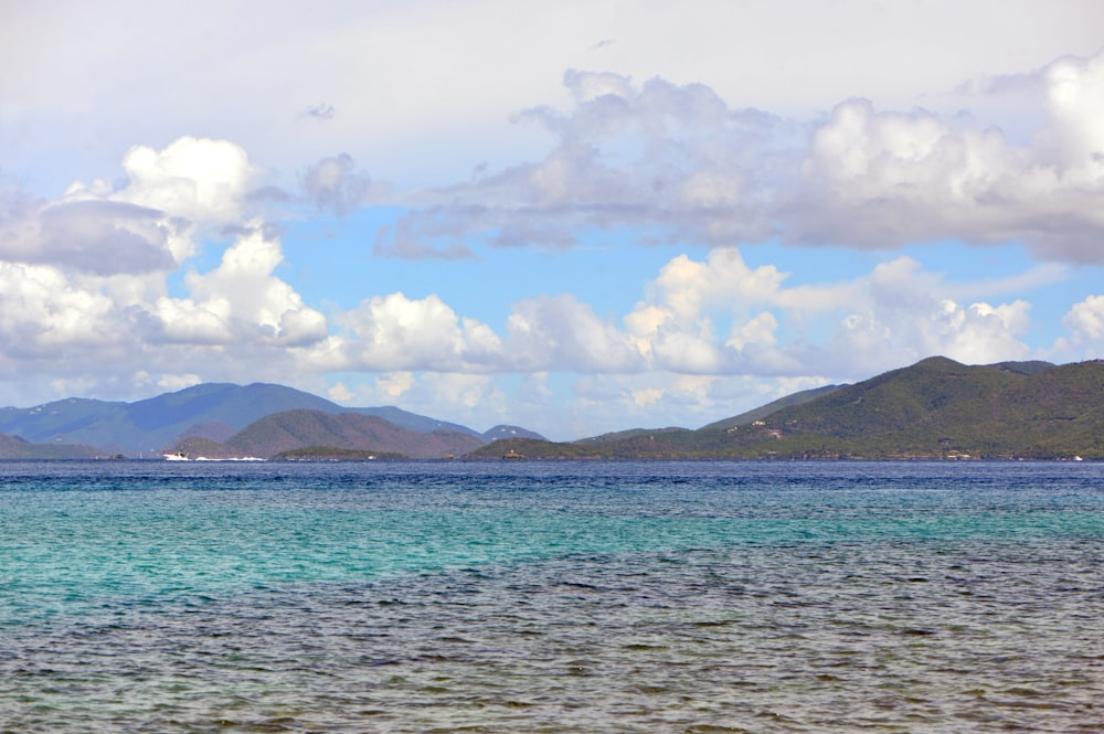 a large body of water with mountains in the background