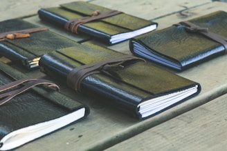 a group of notebooks sitting on top of a wooden table