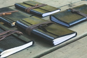 a group of notebooks sitting on top of a wooden table