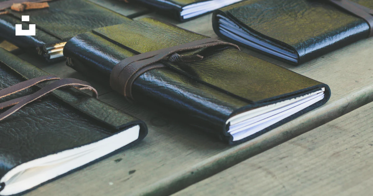 A group of notebooks sitting on top of a wooden table photo – Free ...