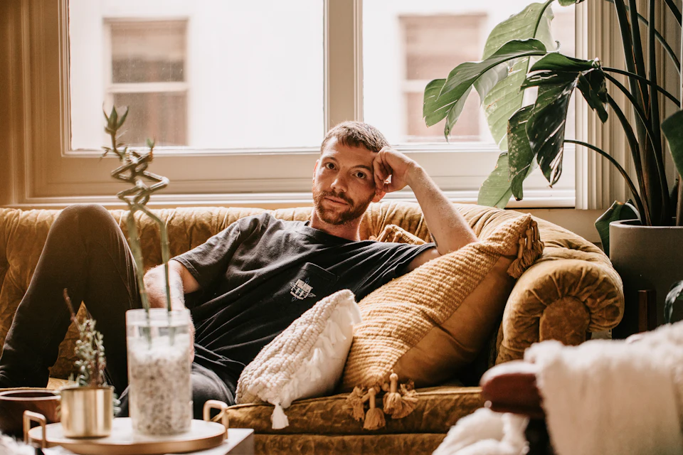 A man stretched out on the sofa at home, smiling