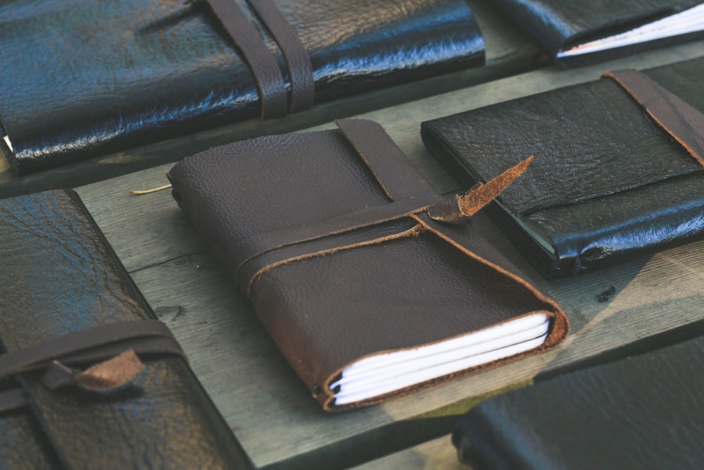 a leather bound notebook sitting on top of a wooden table